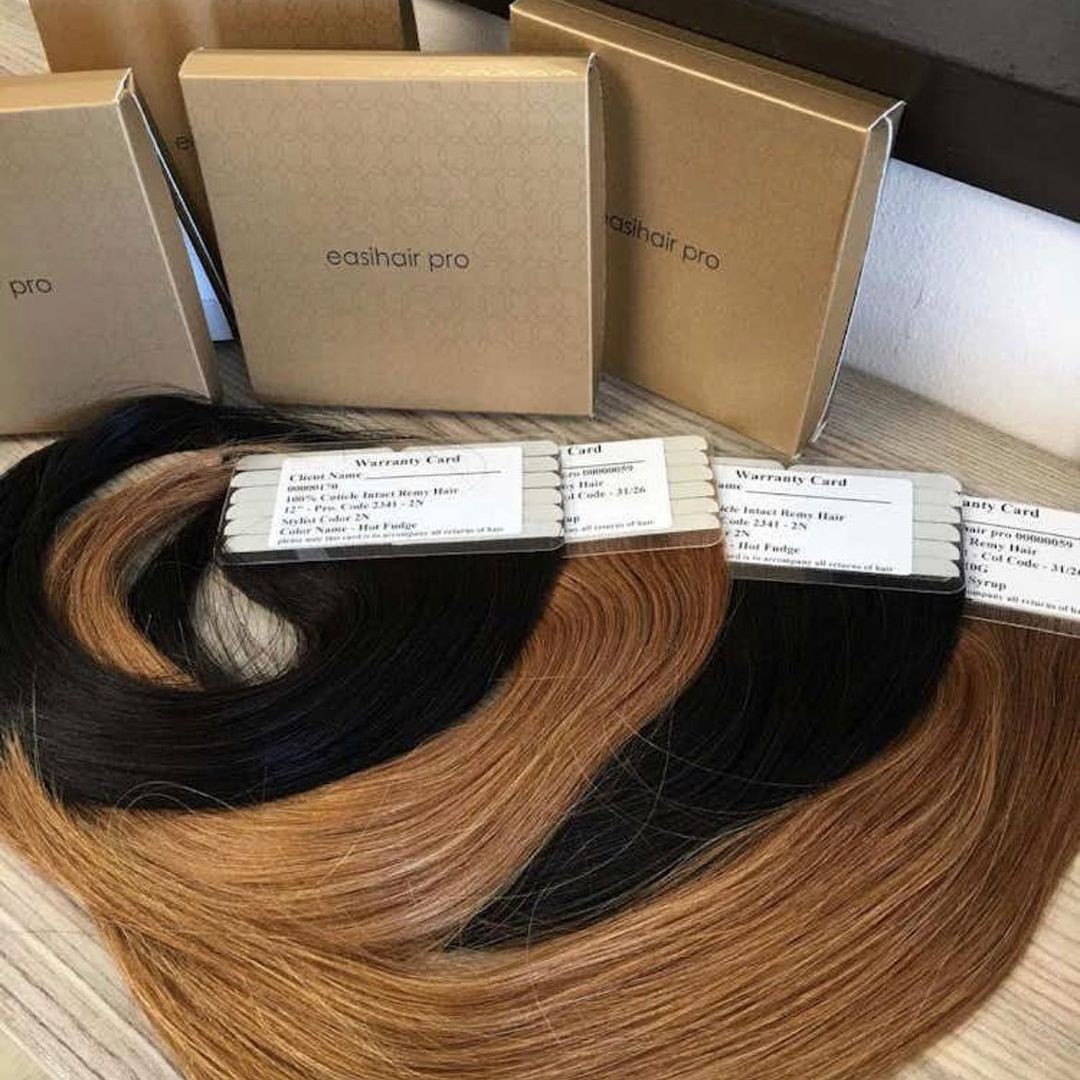 Assortment of hair extensions with warranty cards and easihair pro packaging on a table.