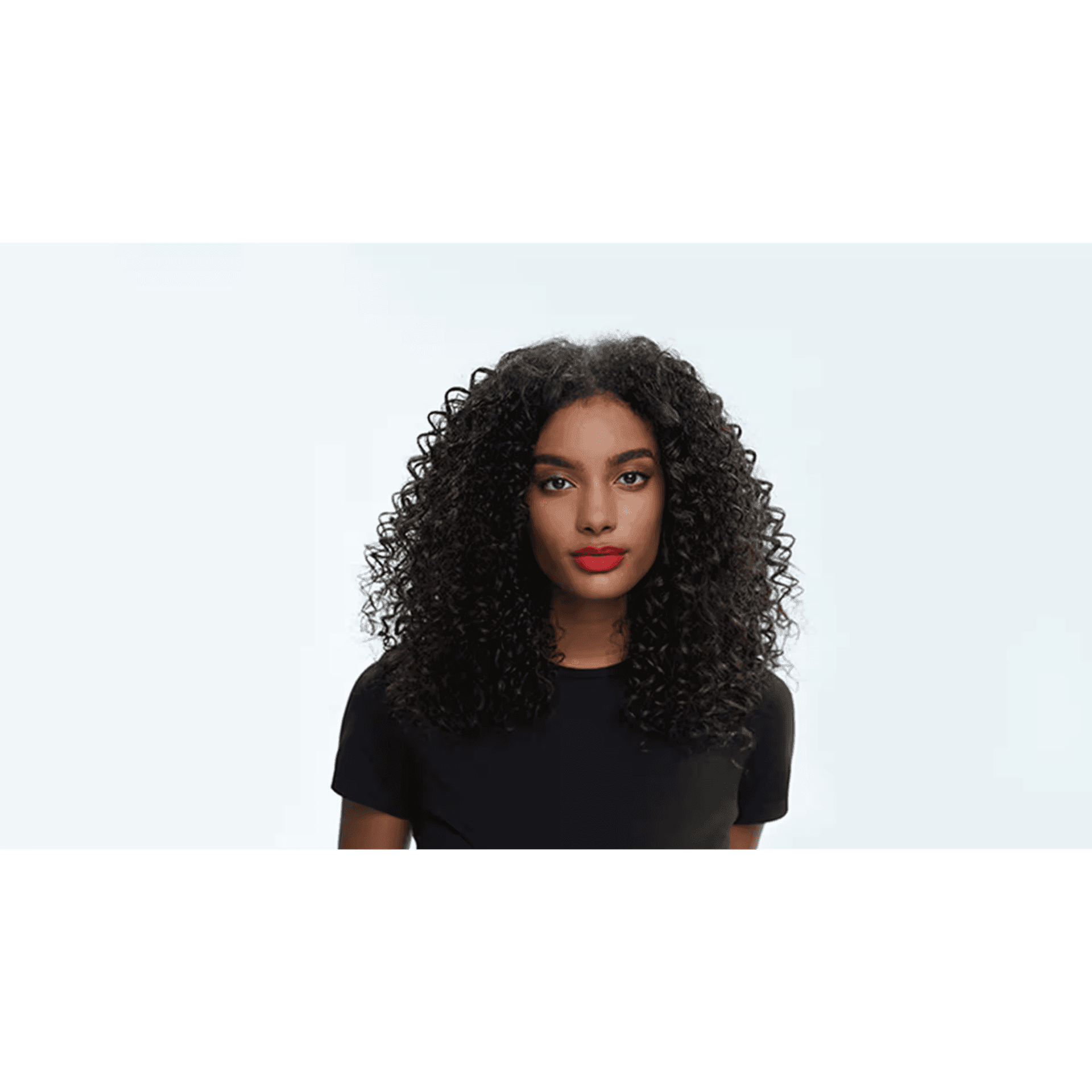 Person with curly black hair wearing a black t-shirt against a light background.