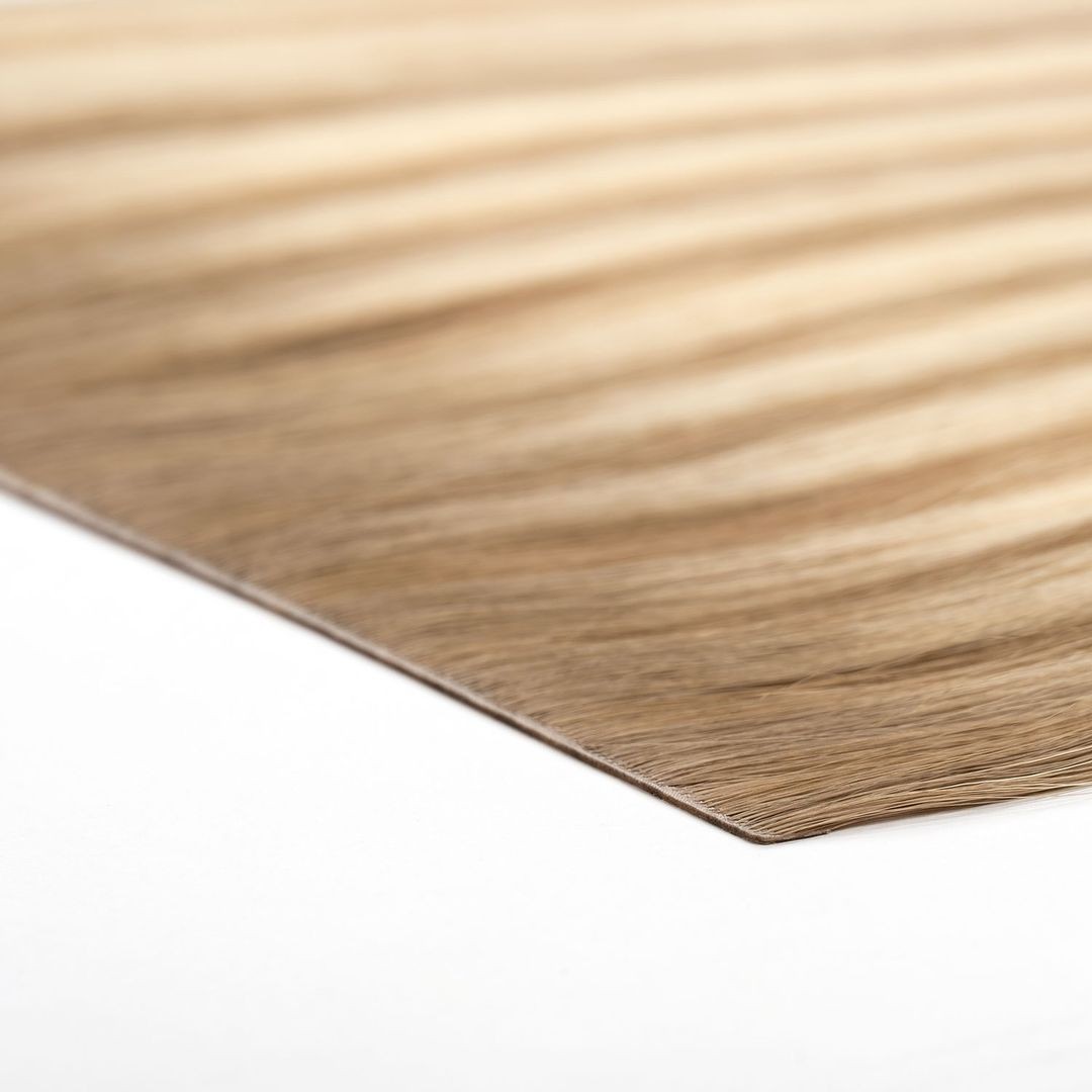 Close-up view of a textured wooden veneer sheet on a white surface.